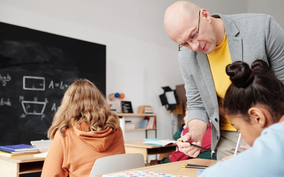 A teacher supporting pupils with their classroom work.