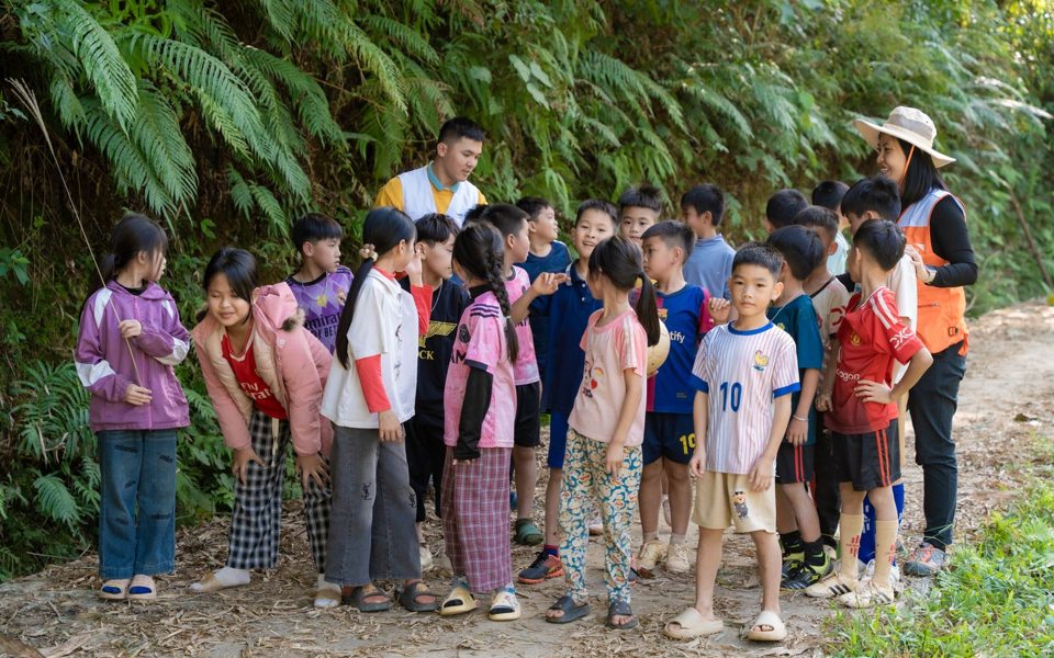 Children and adult guides exploring a woodland trail together.